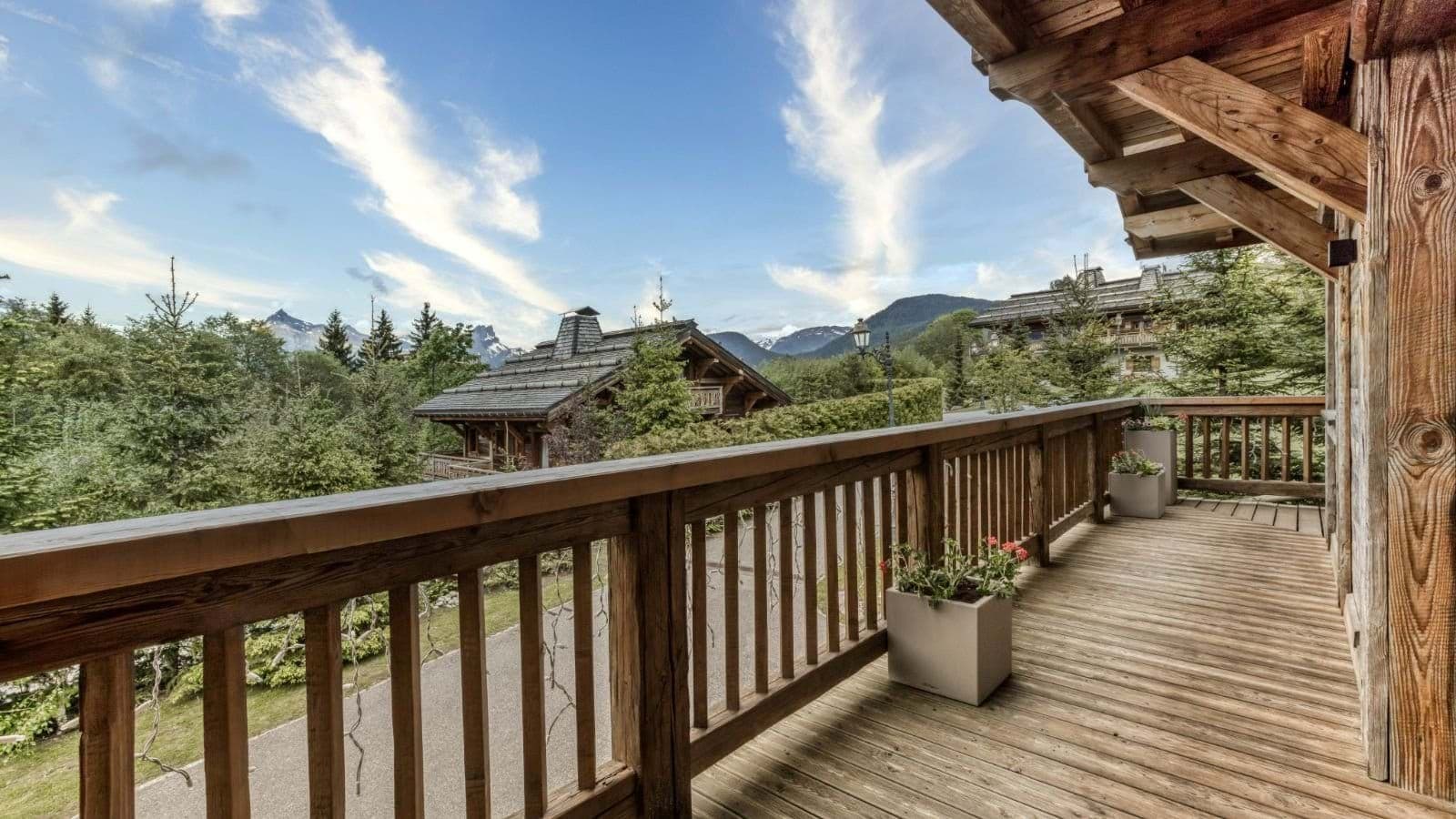 Timber balcony with views of mountain peaks and neighboring chalets
