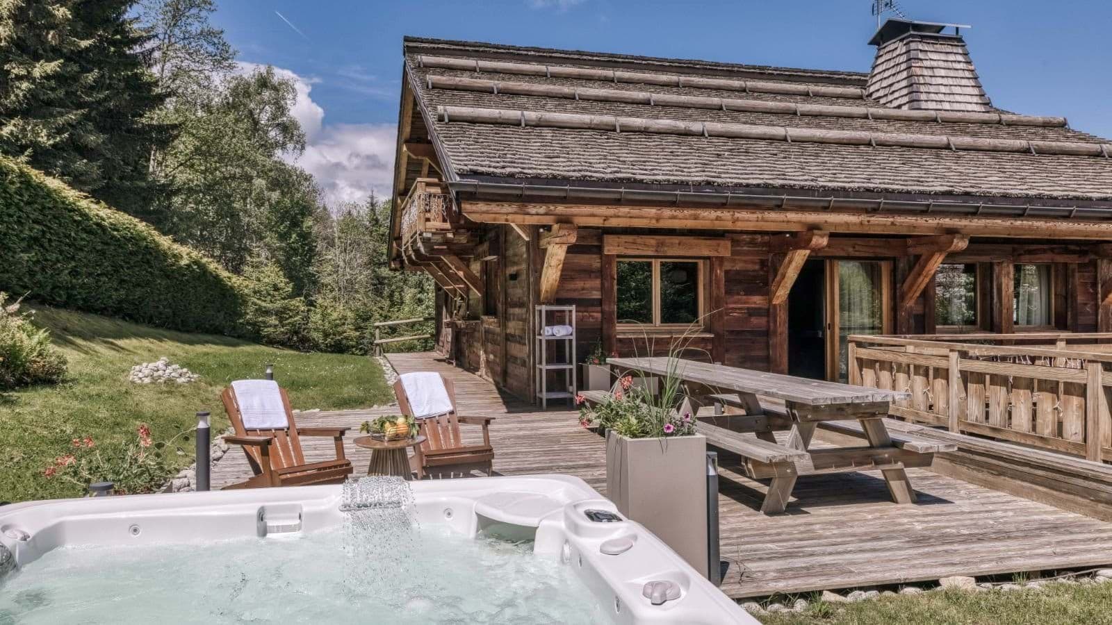 Hot tub with waterfall feature; sun deck includes picnic table and lounge chairs