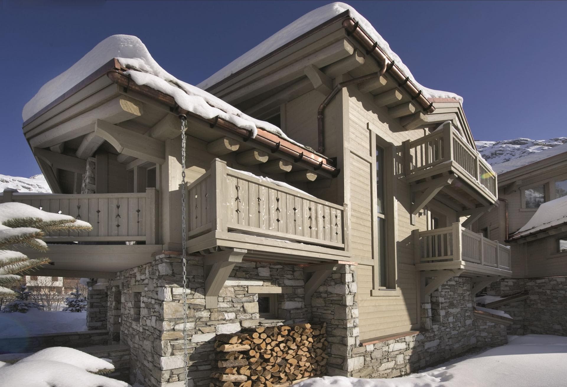 Chalet exterior with multiple private balconies and firewood storage