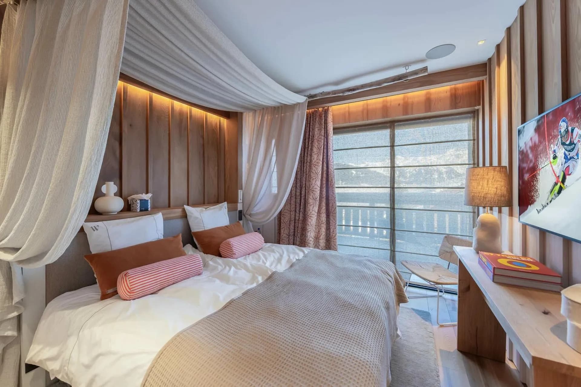 Double bedroom with television and curtained windows