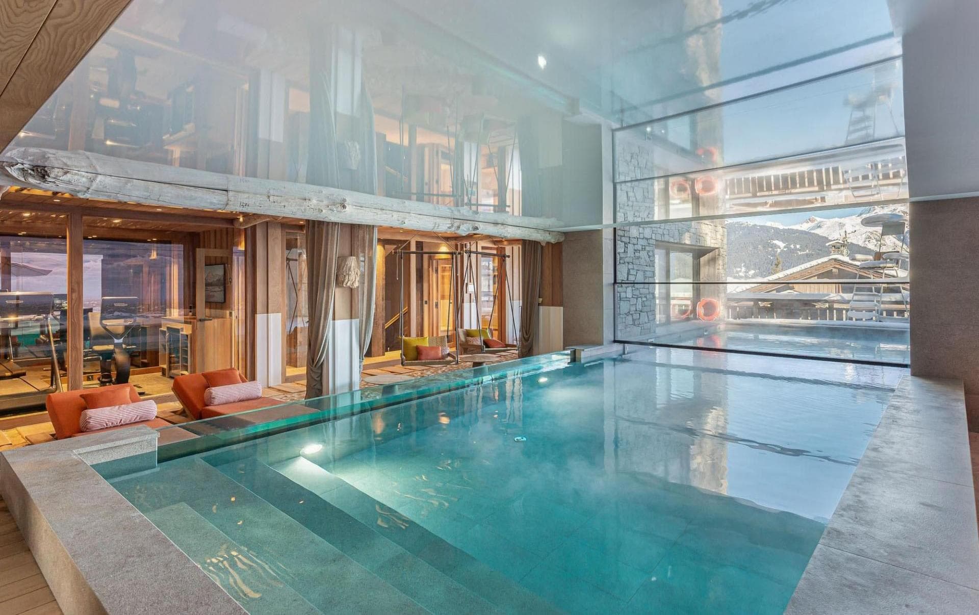 Indoor swimming pool with mountain views beside the fitness area