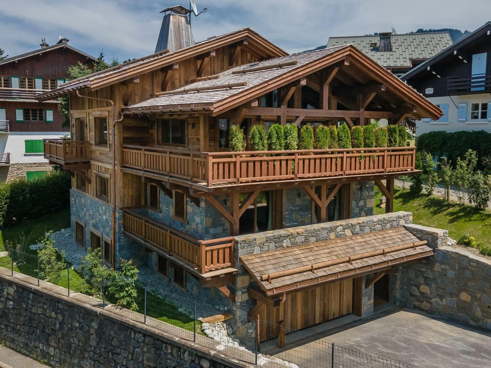 Chalet exterior with three-car garage and wraparound balconies