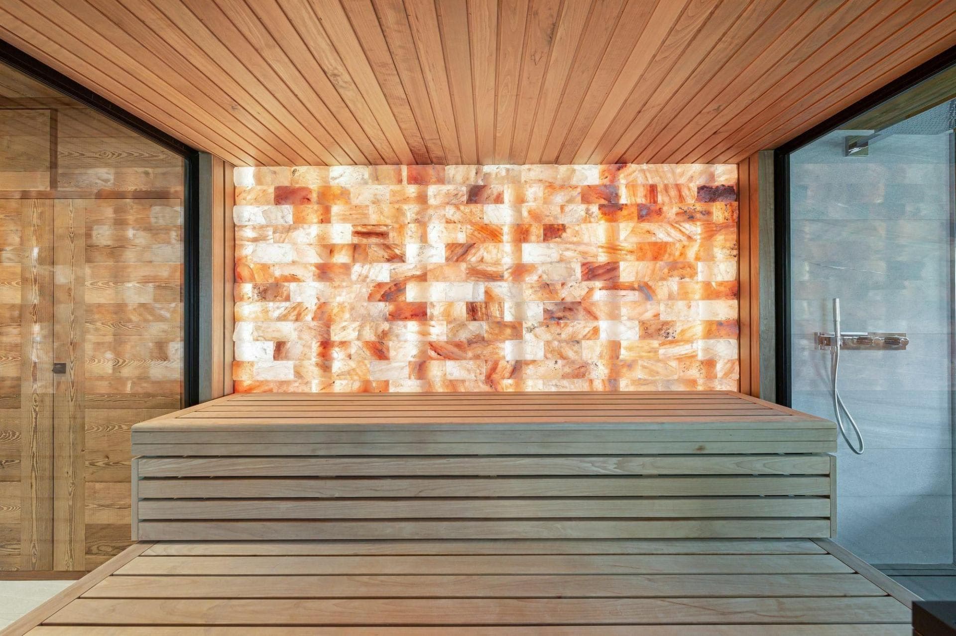 Cedar sauna with backlit Himalayan salt wall and adjacent shower