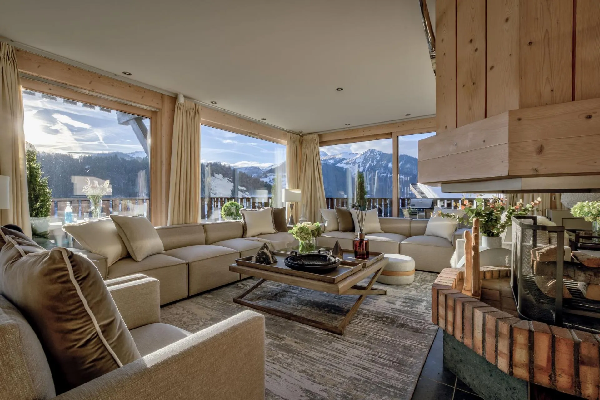 Living room with wood-burning fireplace and floor-to-ceiling mountain views