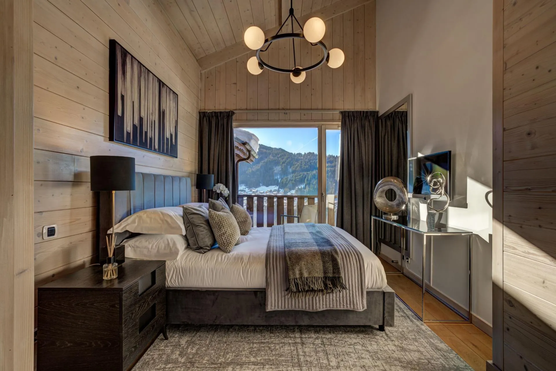 Bedroom with vaulted ceilings, king bed, and mountain-view balcony
