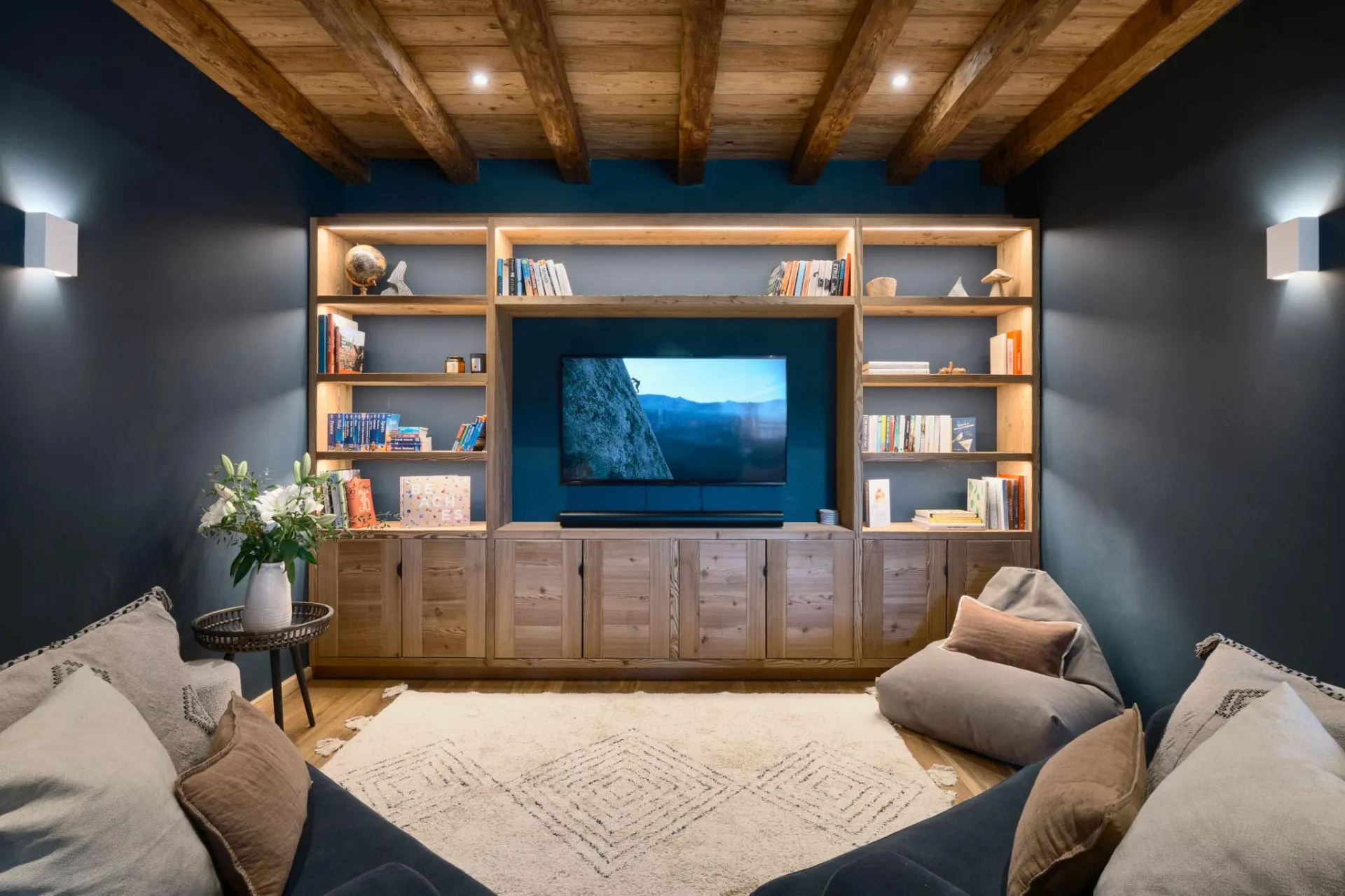 TV area with armchairs and wood-panelled storage