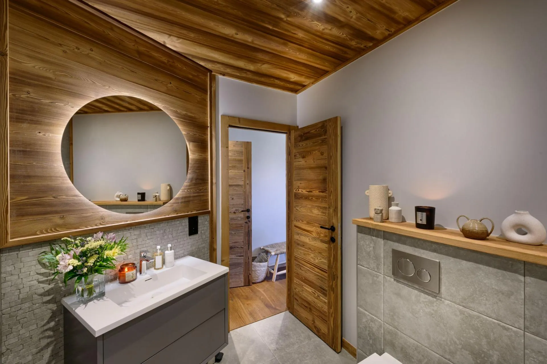 Bathroom vanity with a circular illuminated mirror