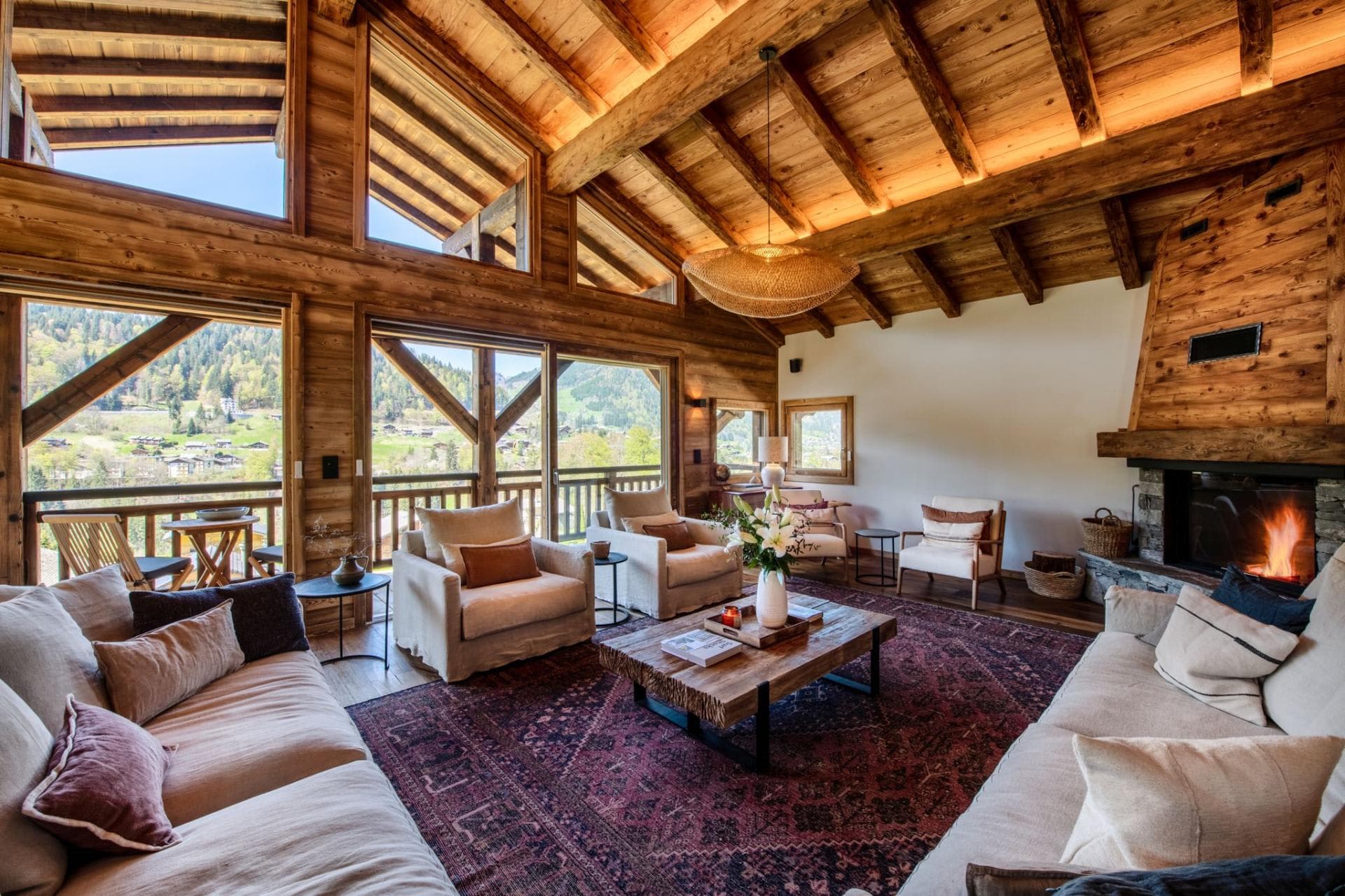 Living area with wood-burning fireplace and floor-to-ceiling valley views
