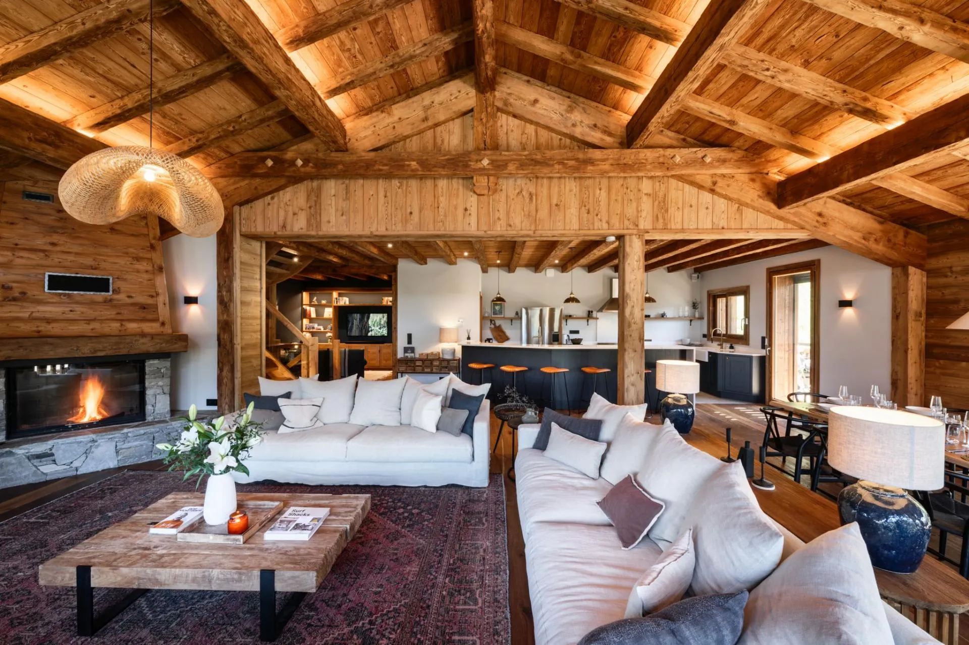 Open-plan living area with timber beams and mountain views