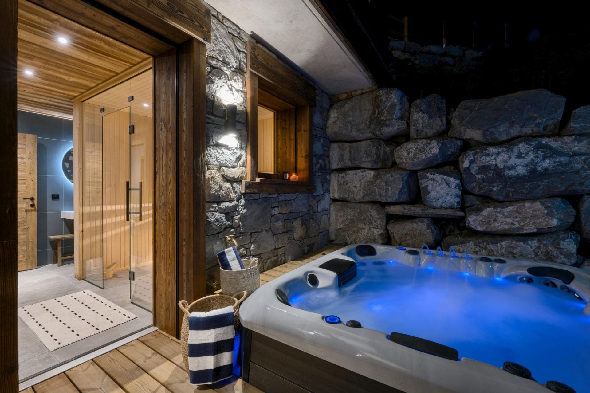 Outdoor hot tub adjacent to glass-fronted sauna and wellness area