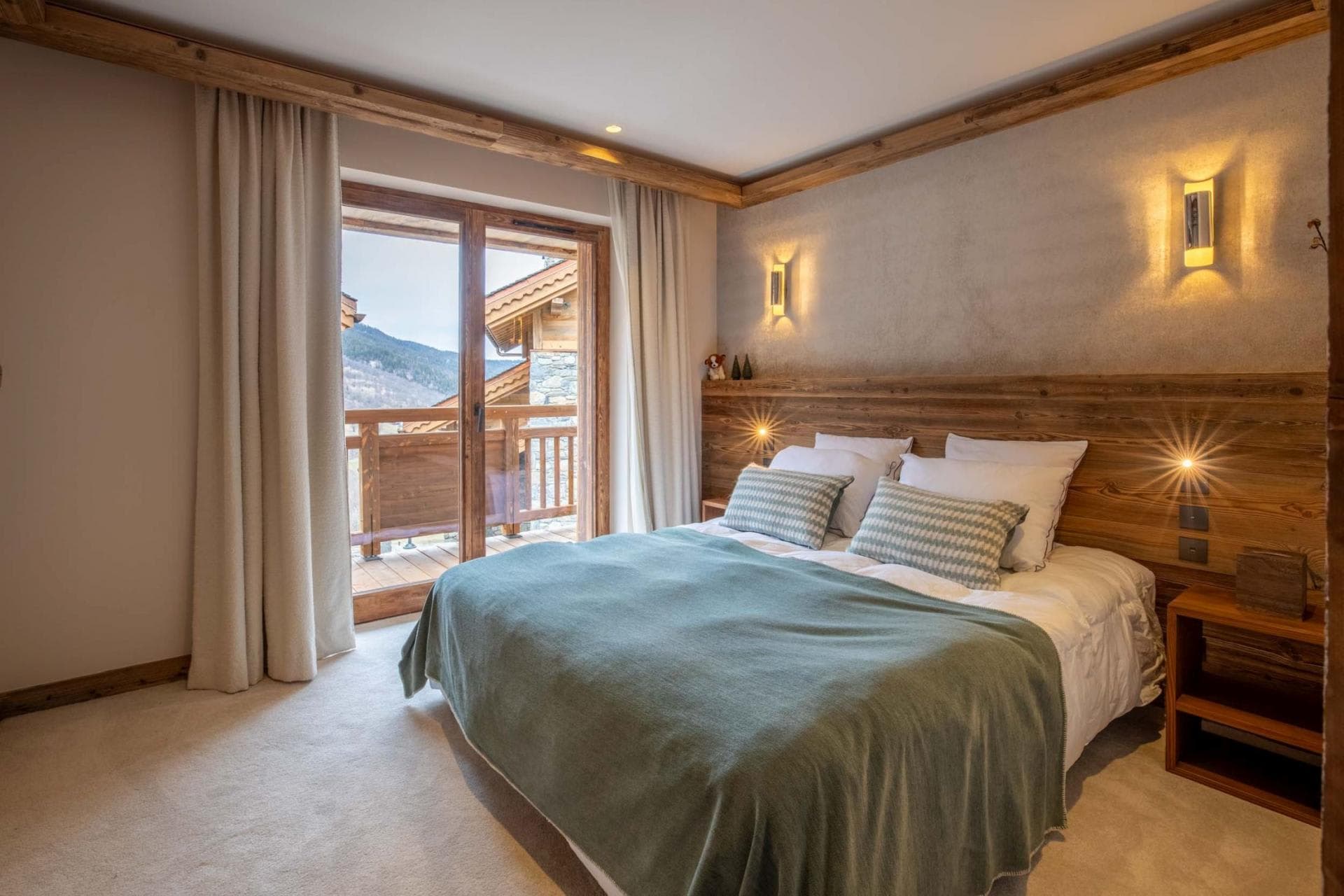 Bedroom with queen bed and private balcony access to mountain views