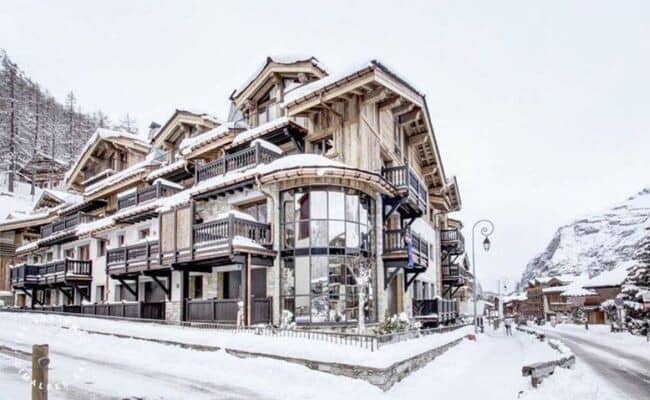 Chalet exterior with private balconies and floor-to-ceiling curved glass windows