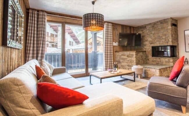 Living room with stone fireplace and balcony access