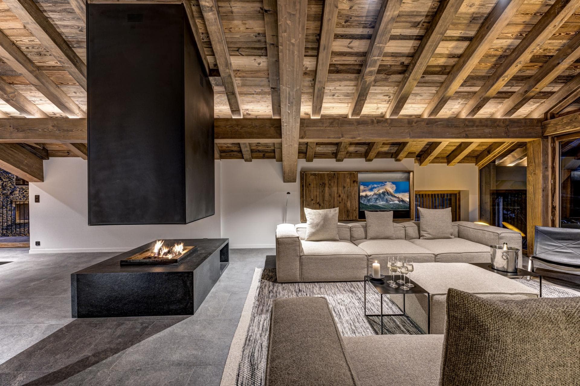 Living area with suspended fireplace and vaulted timber ceilings