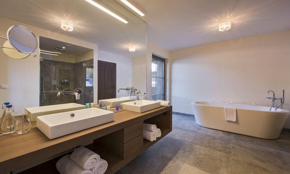 Bathroom with dual vessel sinks, soaking tub, and walk-in rain shower