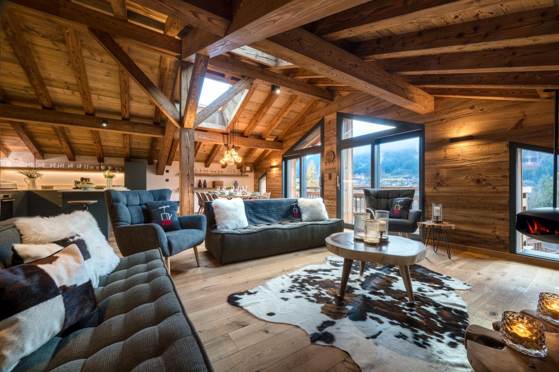 Open-plan living area with vaulted timber ceilings and suspended fireplace