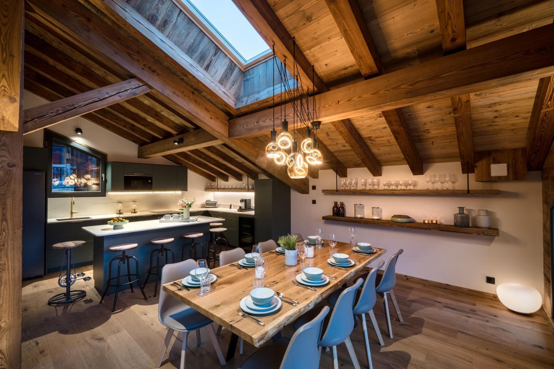 Open-plan dining area seats 10 under vaulted ceilings with skylight