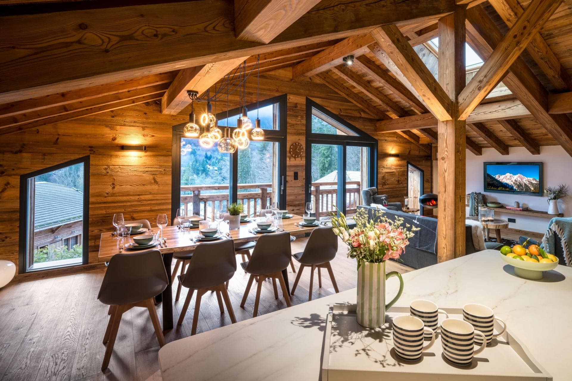 Dining area beside floor-to-ceiling windows with mountain views