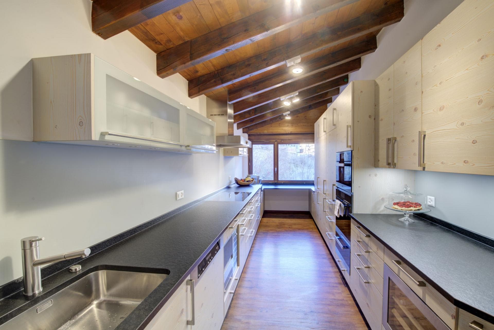 Galley kitchen with vaulted wood ceilings and integrated wine cooler