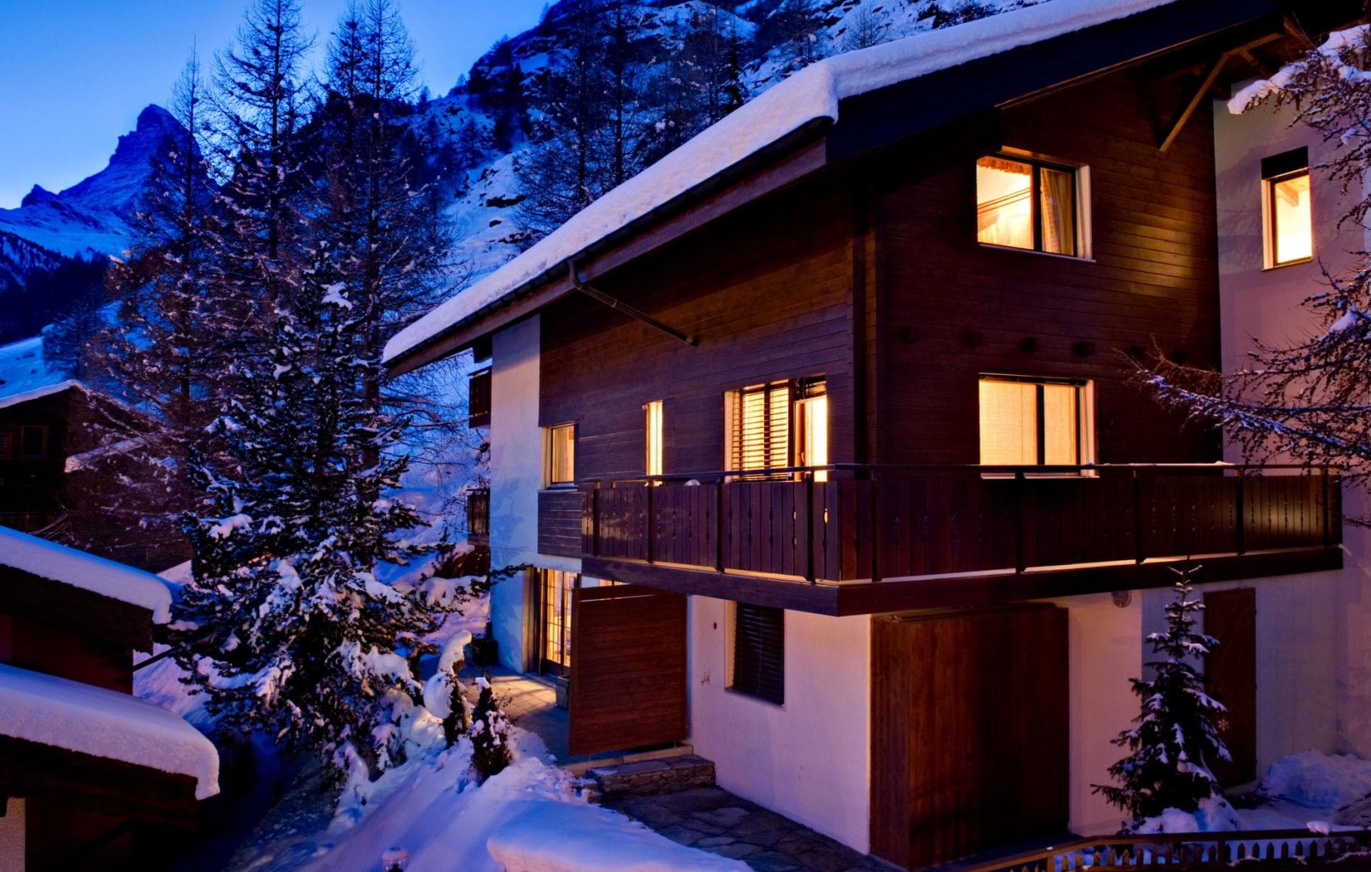 Chalet exterior at dusk with Matterhorn views and wrap-around balcony