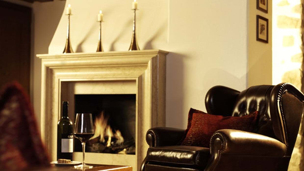 Stone fireplace and leather armchair in living area