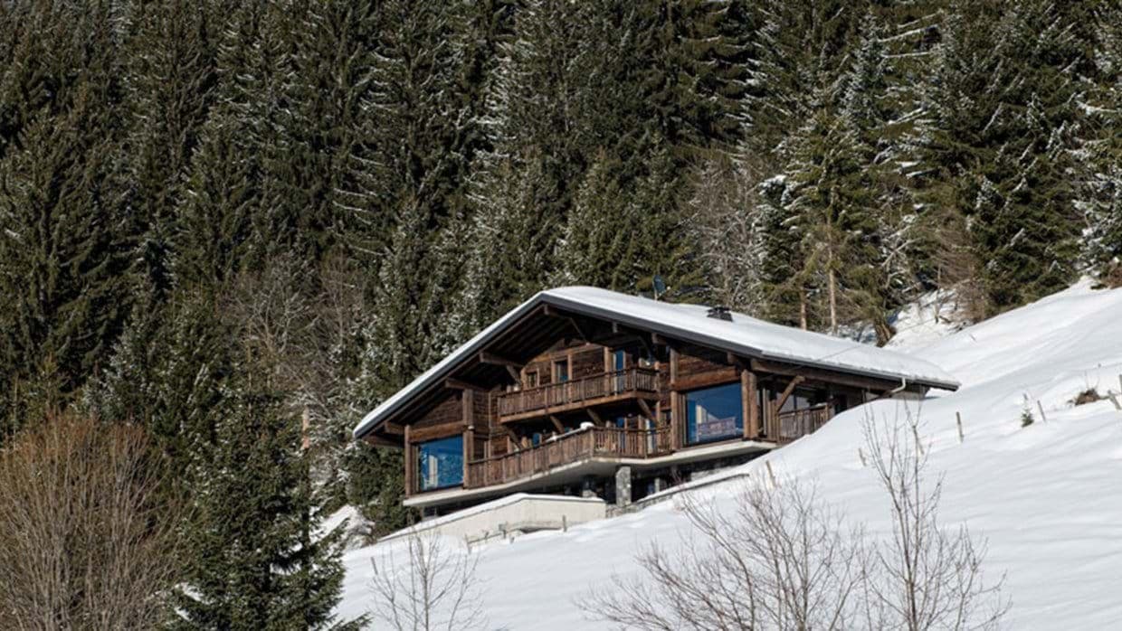 Ski-in/ski-out chalet with tiered balconies and forested mountain backdrop