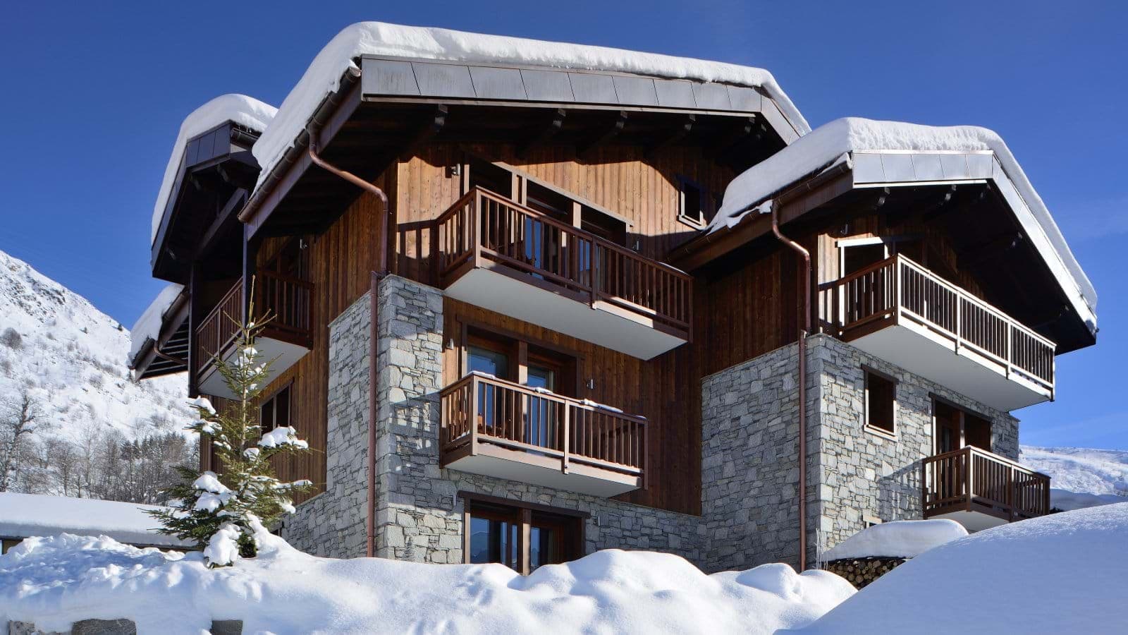 Chalet exterior with stone masonry and private balconies for each floor