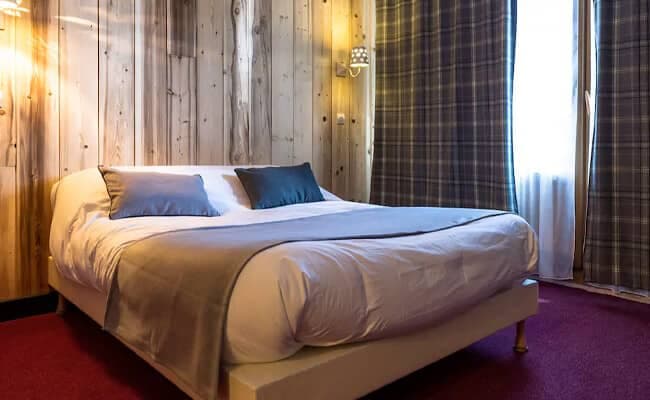Guest bedroom with queen bed and rustic wood paneling