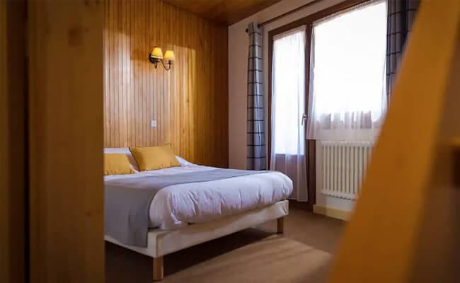 Guest bedroom with double bed and wood paneling