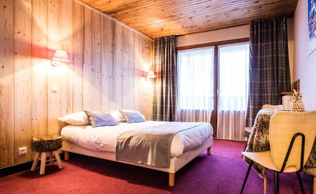 Bedroom with queen bed and wood-paneled accent wall