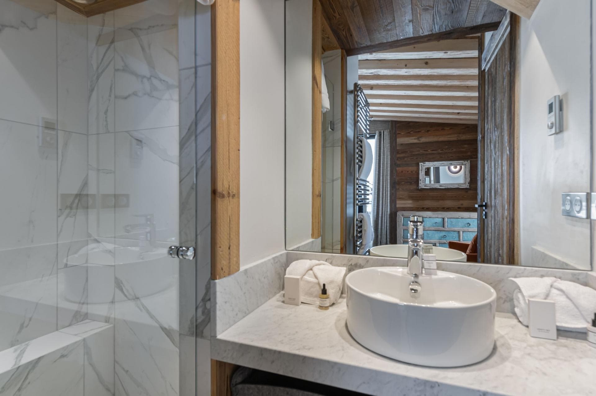 Bathroom featuring marble vanity, vessel sink, and glass-enclosed walk-in shower