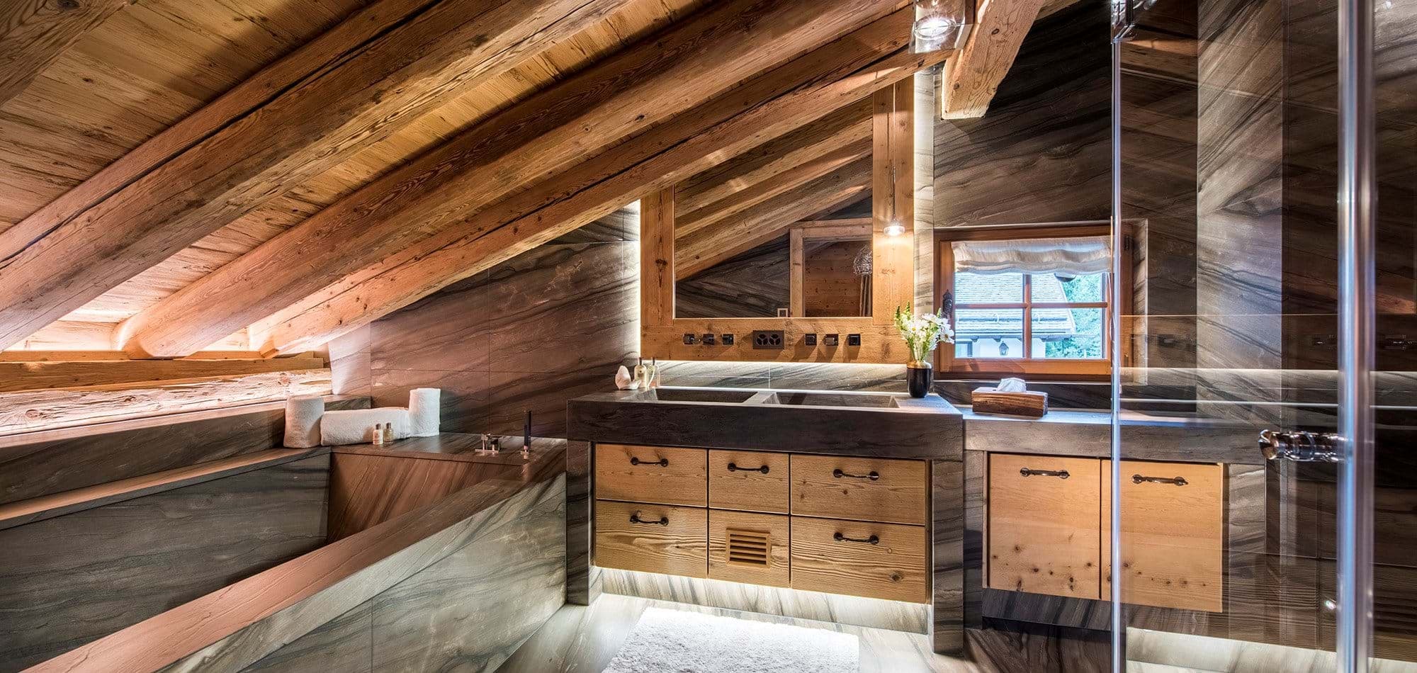 Bathroom with dual vanity, stone bathtub, and walk-in shower
