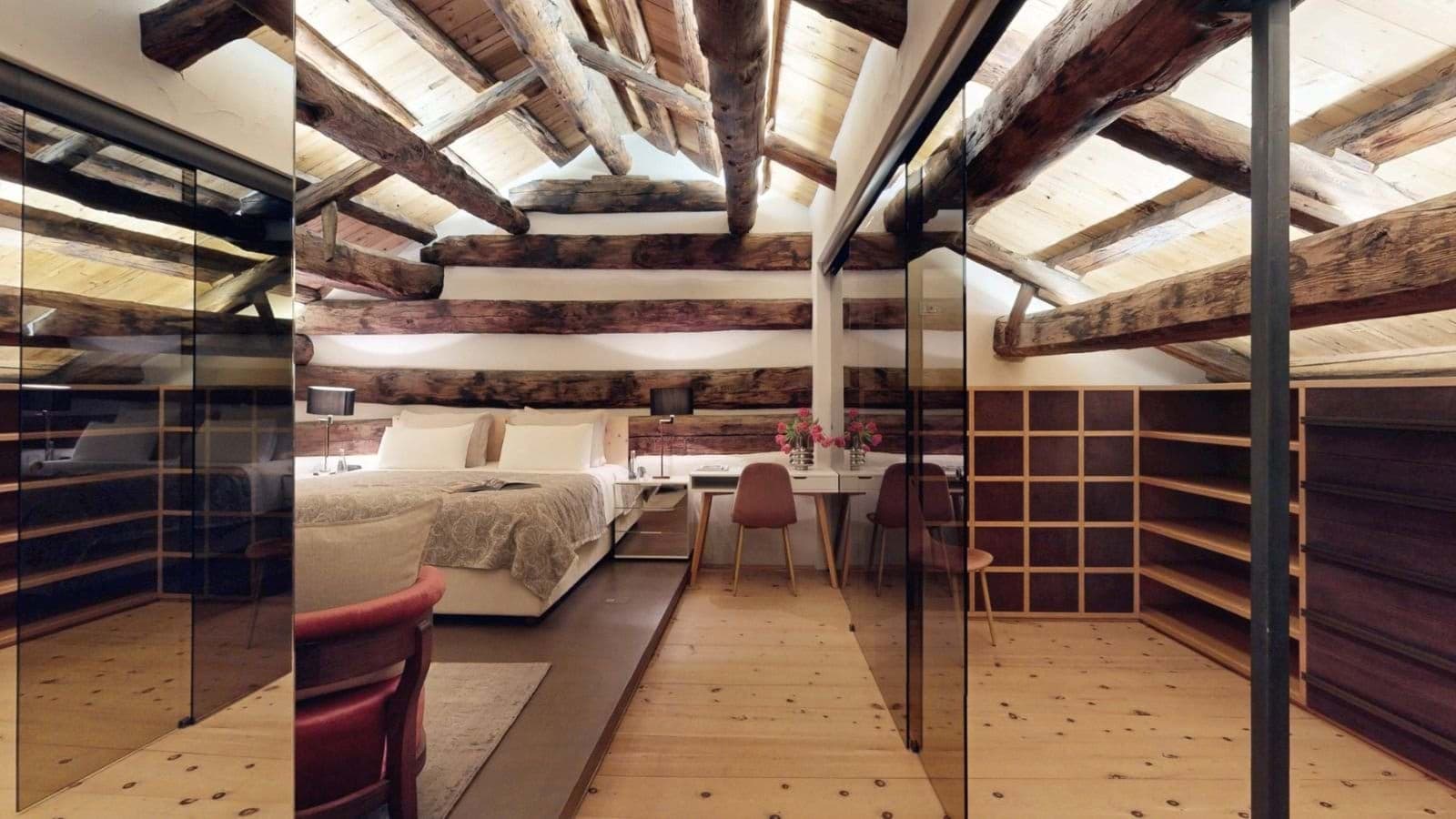 Loft bedroom with exposed timber beams and built-in shelving