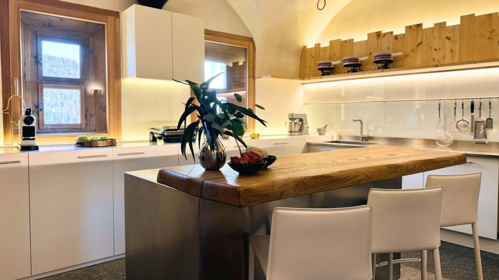 Kitchen with Nespresso machine, wood island, and breakfast bar seating for 3