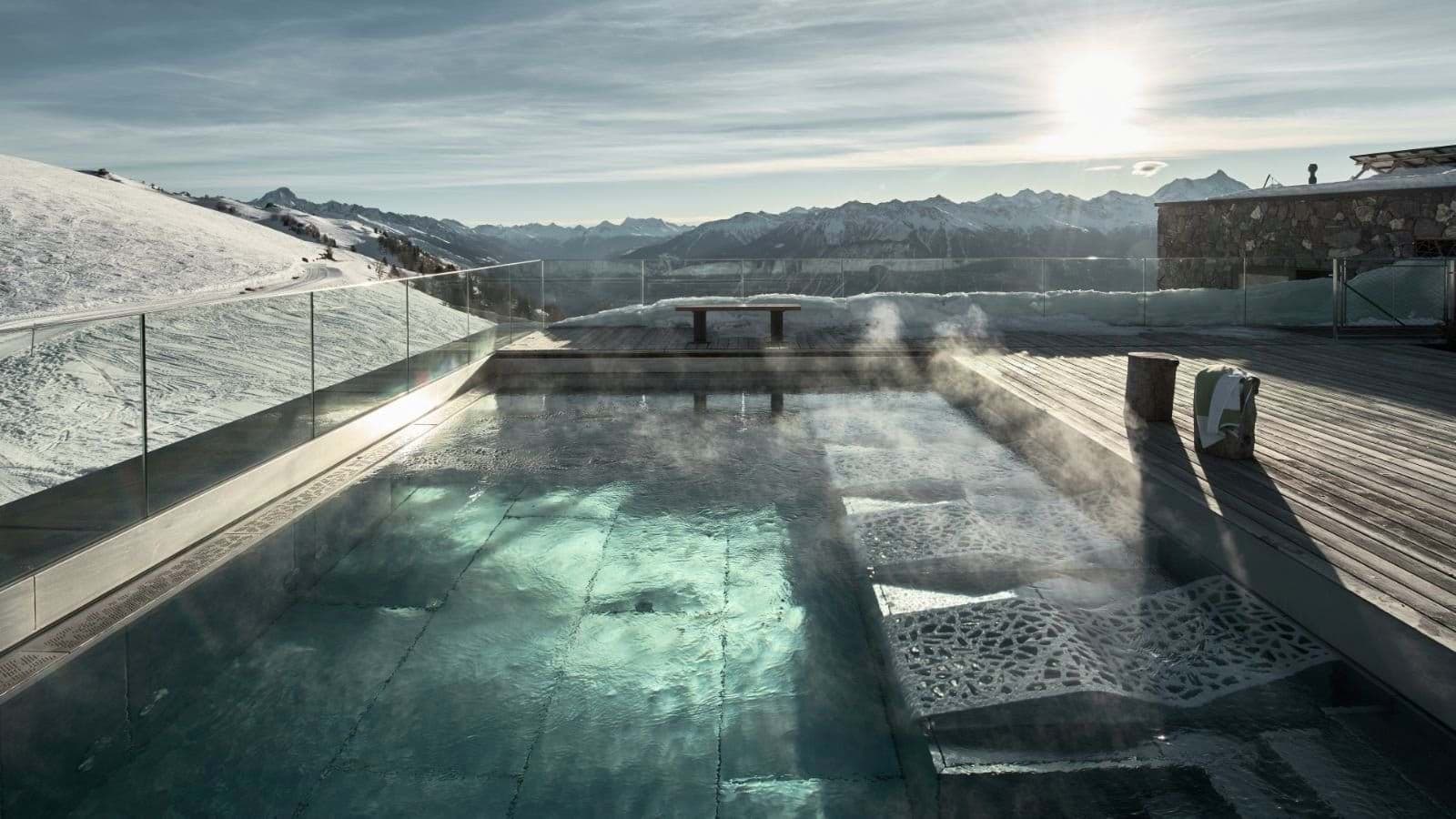 Heated outdoor pool with glass railings and panoramic mountain views