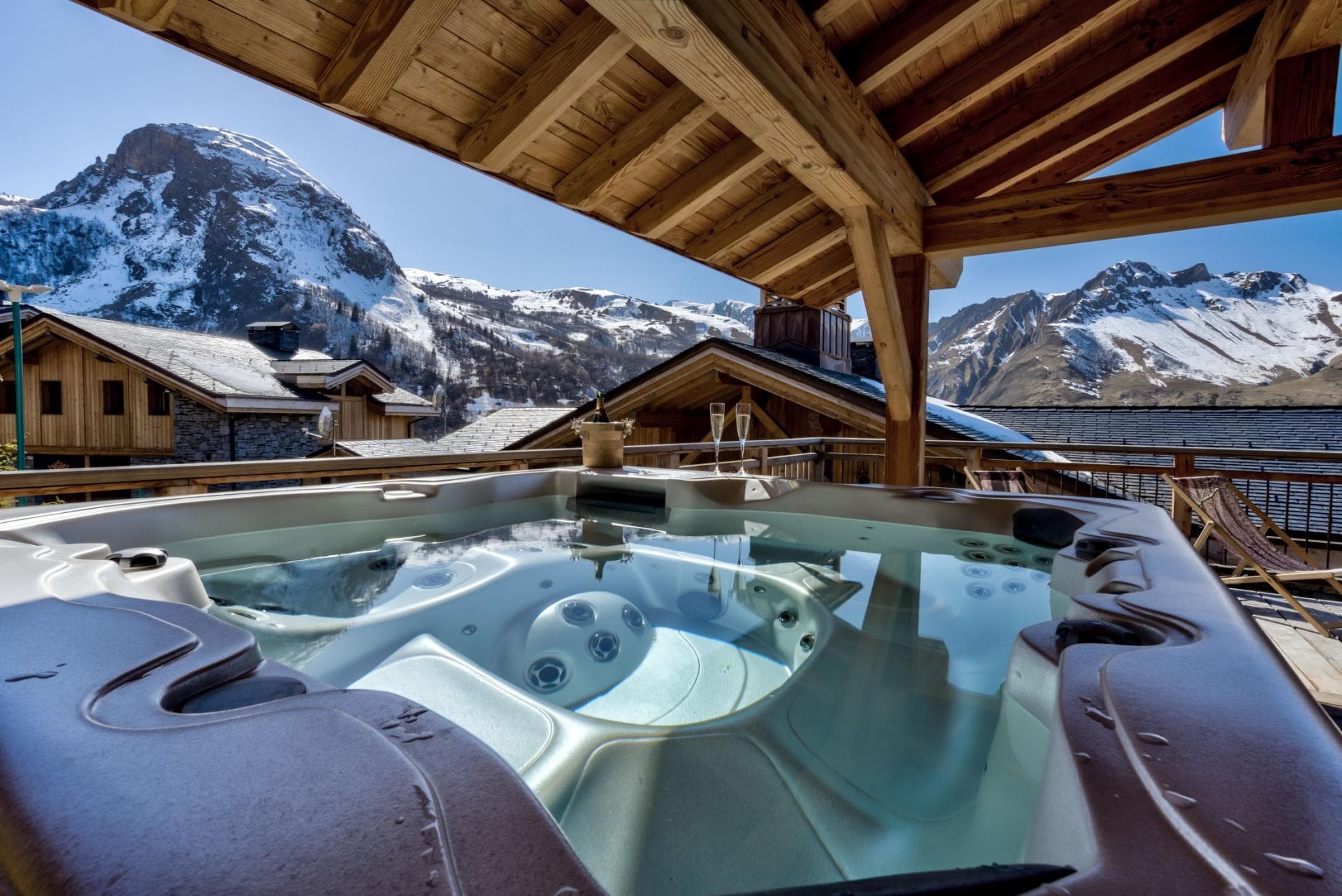 Covered outdoor hot tub with seating for 6 and alpine mountain views
