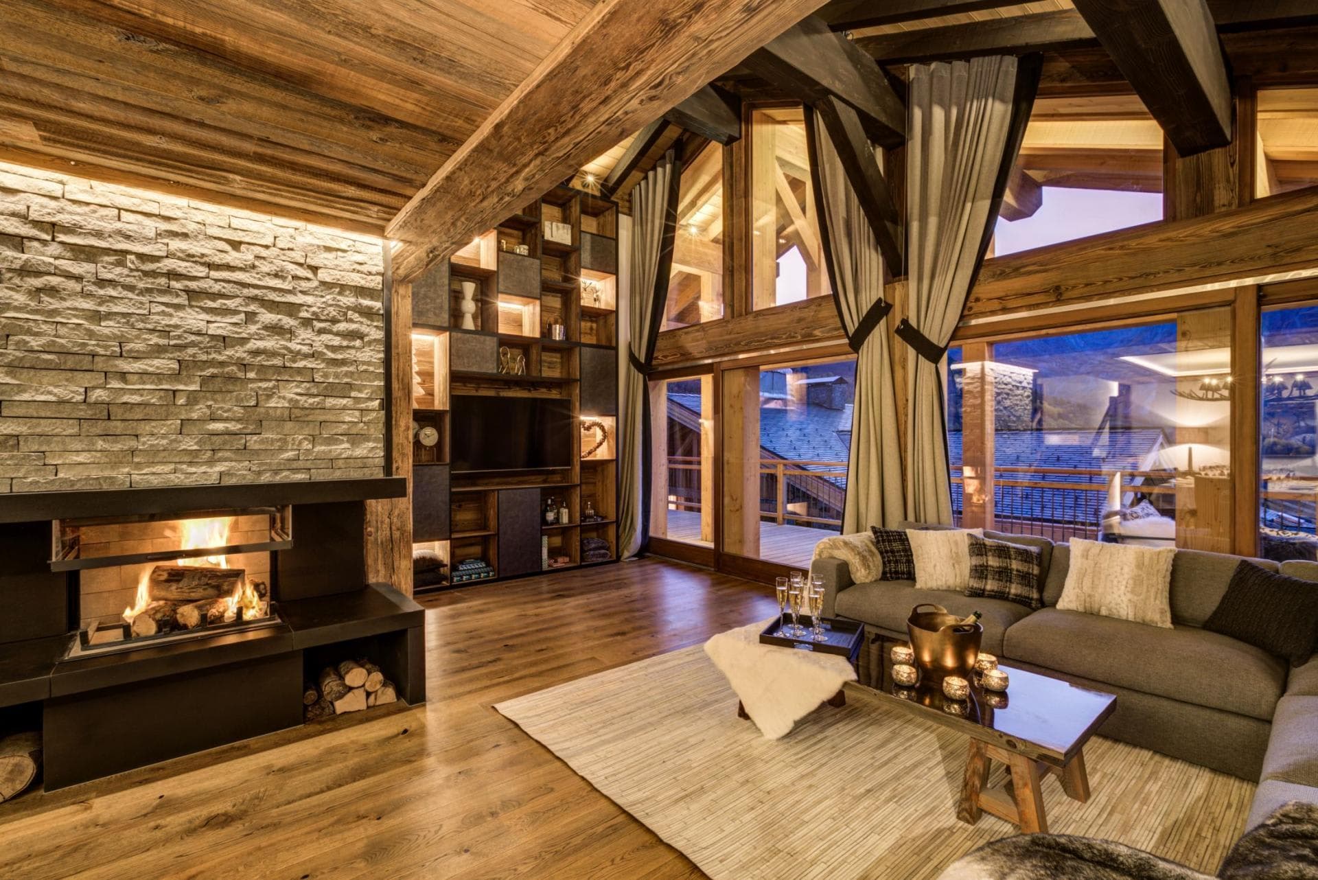 Living area with wood-burning fireplace and floor-to-ceiling mountain views