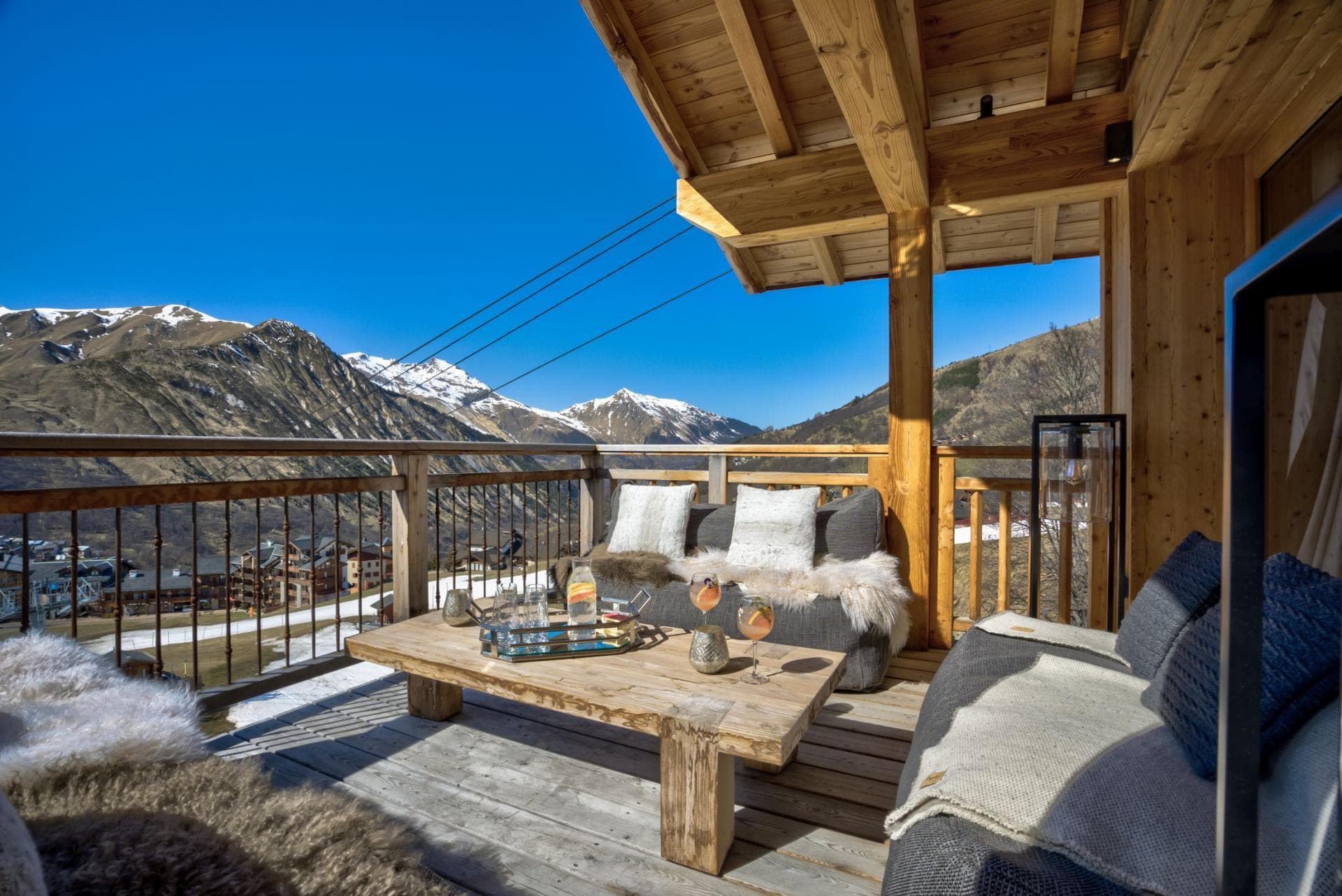 Covered timber balcony with lounge seating and panoramic alpine views
