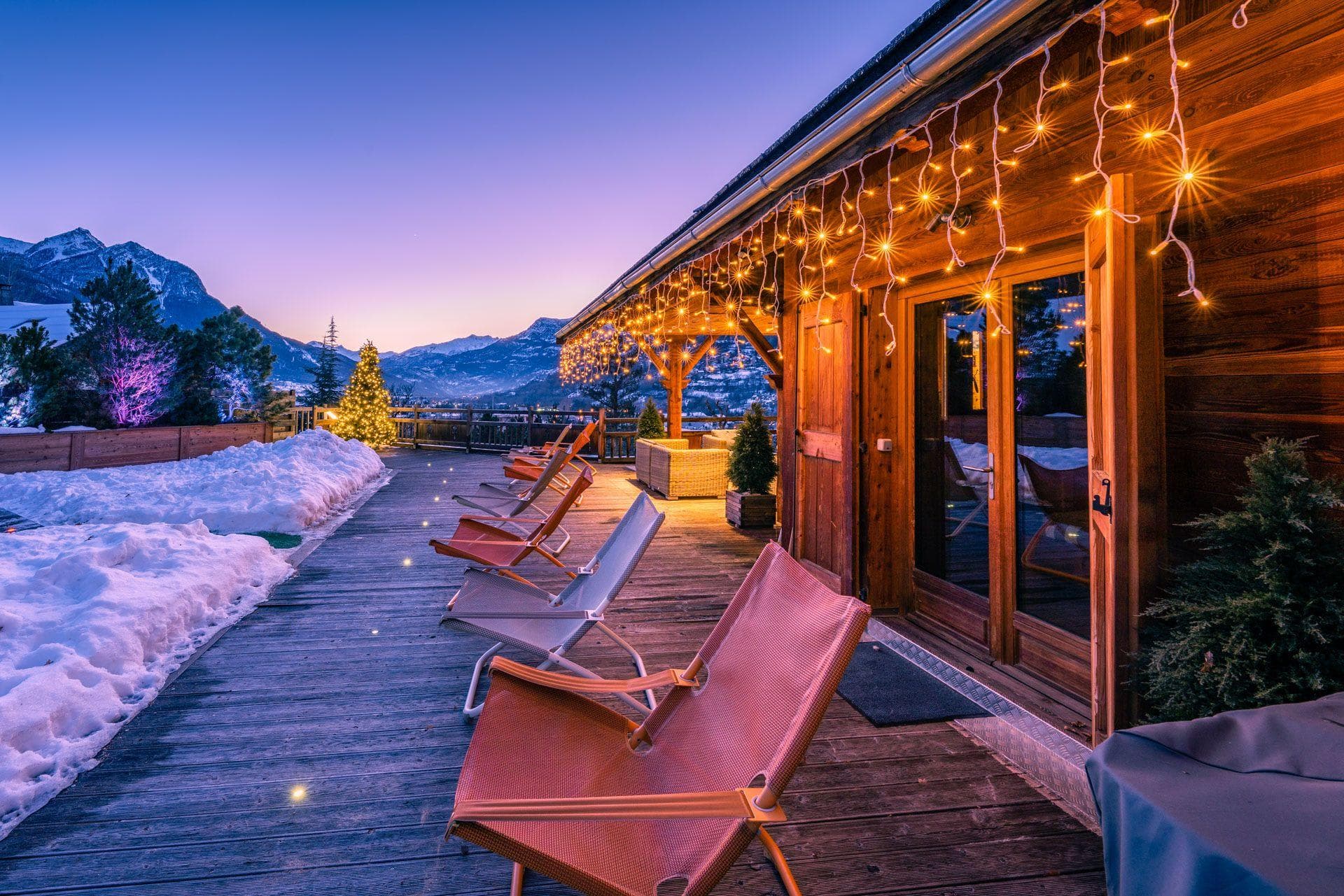 Chalet deck with lounge seating and mountain range sunset view