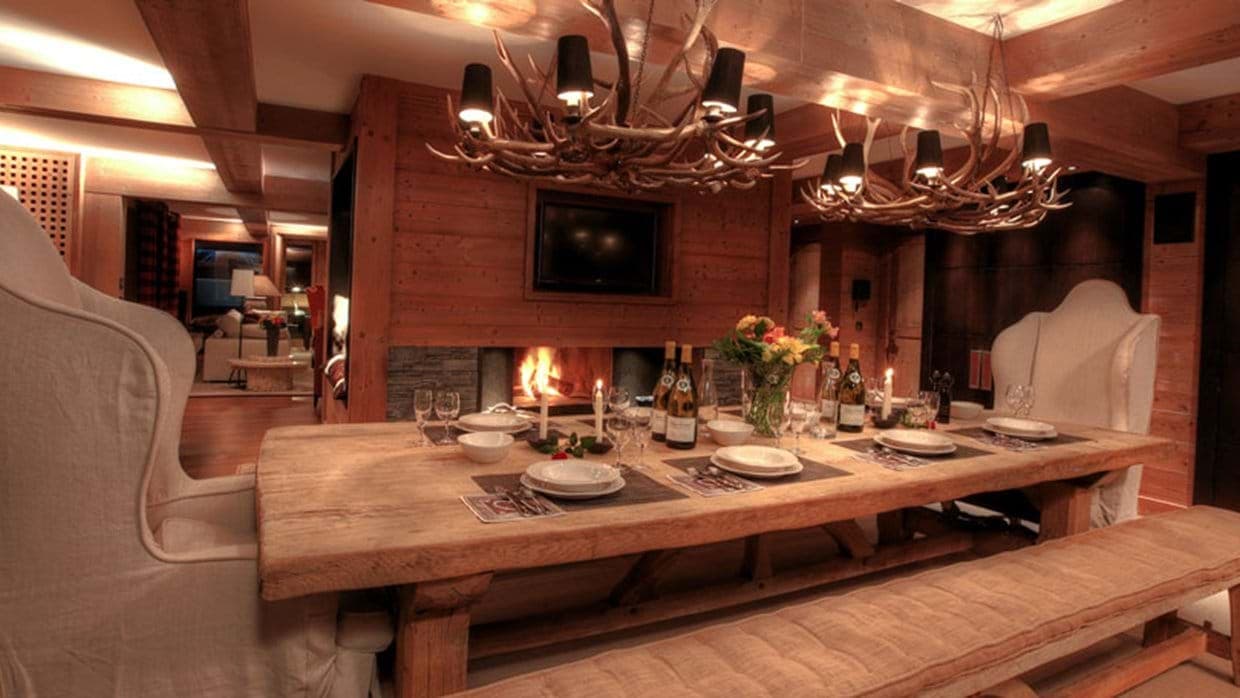 Dining area seats 10 with wood-burning fireplace and antler chandeliers