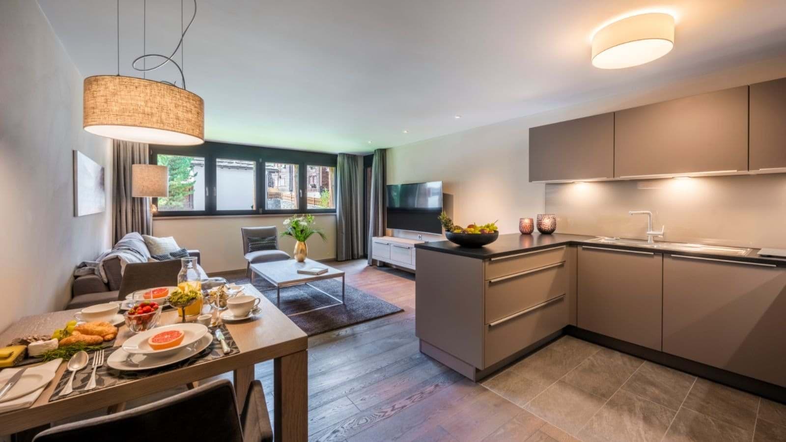 Open-plan living area with integrated kitchen, dining for 4, and smart TV