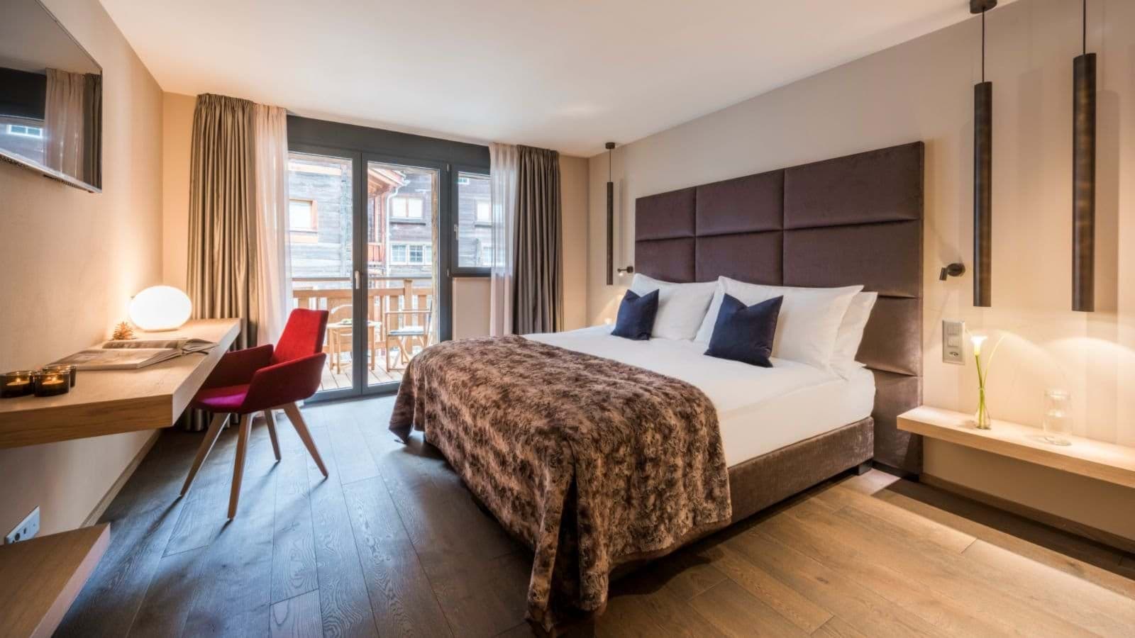 Primary bedroom with king bed, dedicated workspace, and private balcony access