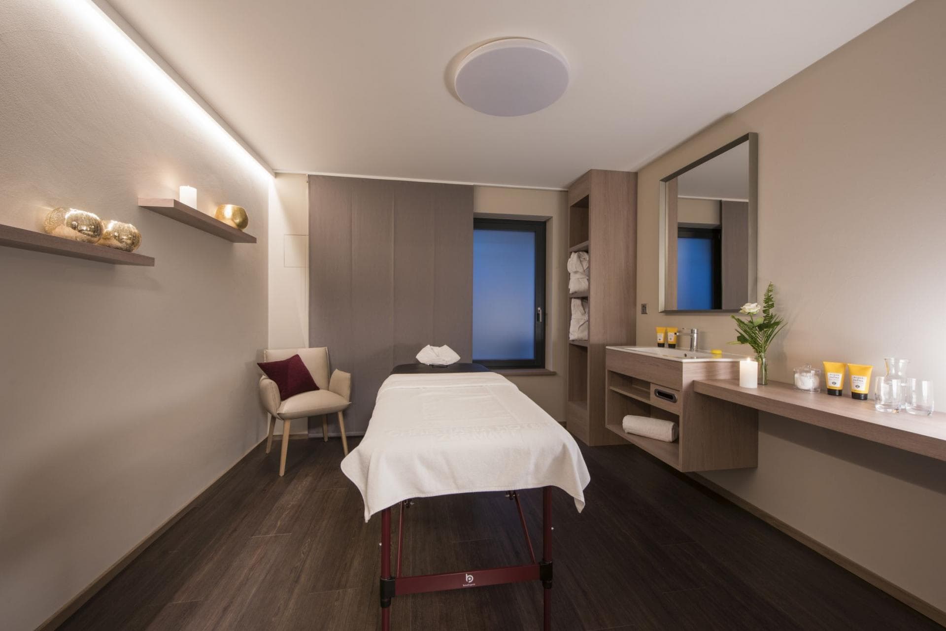 Private massage room with treatment table and vanity sink