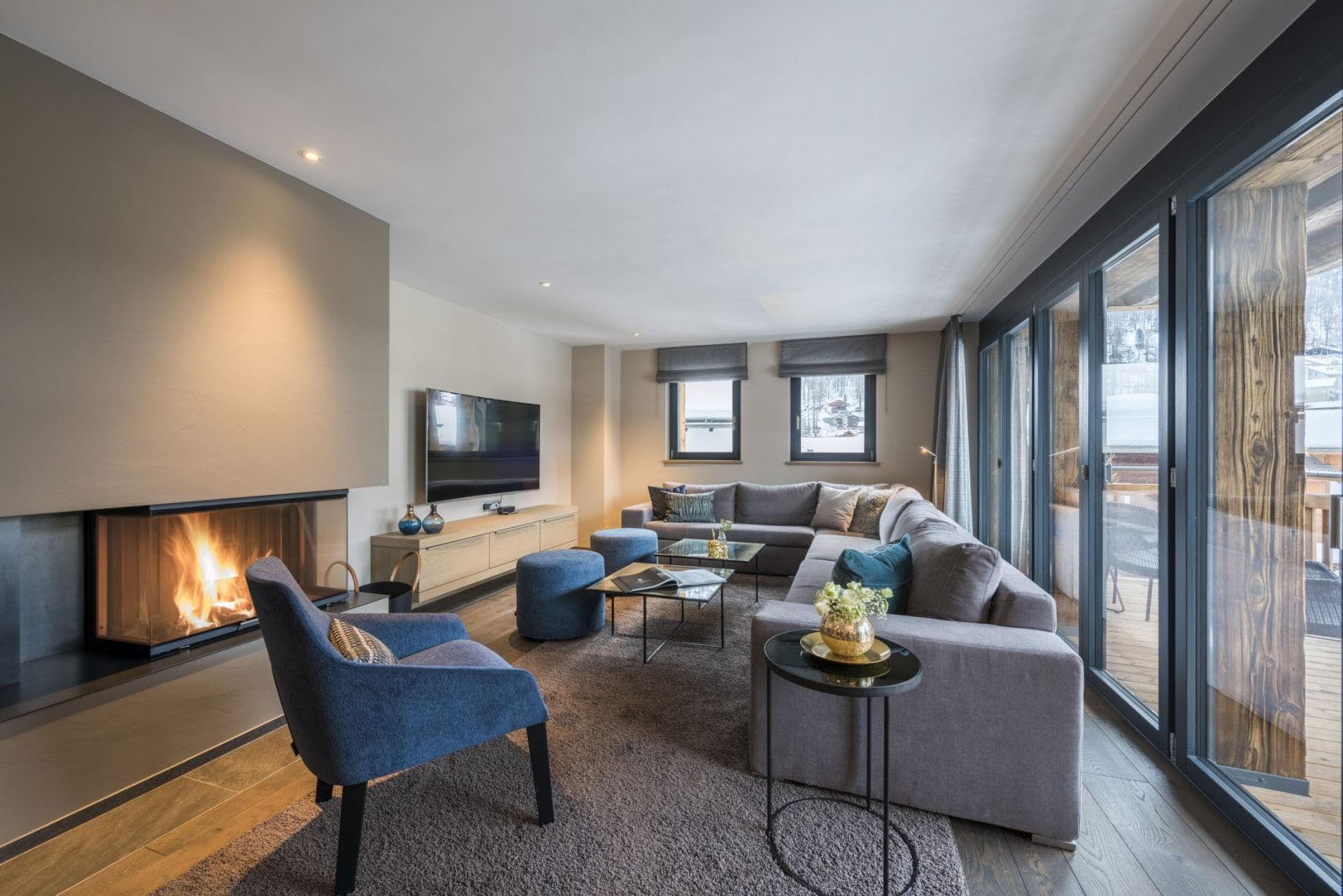Living area with wood-burning fireplace and floor-to-ceiling balcony access