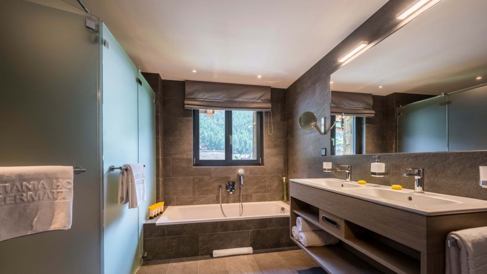 Bathroom with dual vanity, deep soaking tub, and frosted glass shower