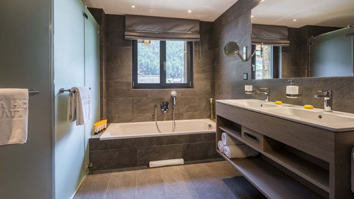 Primary bathroom with dual vanity, soaking tub, and heated floors