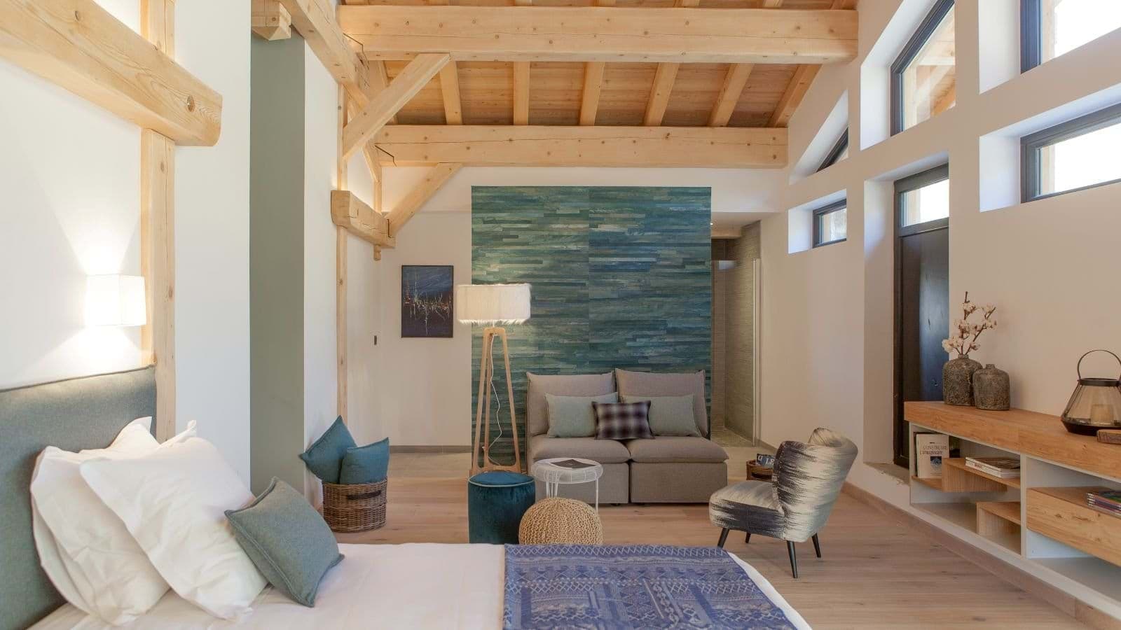 Primary bedroom with timber vaulted ceiling and separate seating area