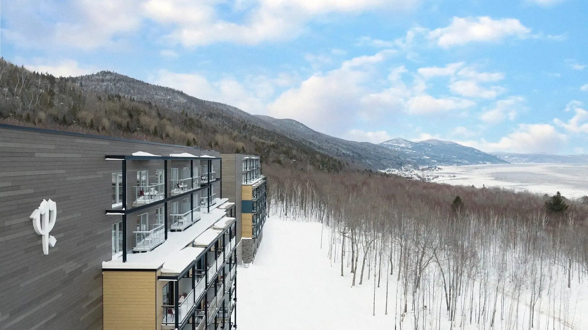 Ski-in/ski-out resort exterior with private balconies and St. Lawrence River views