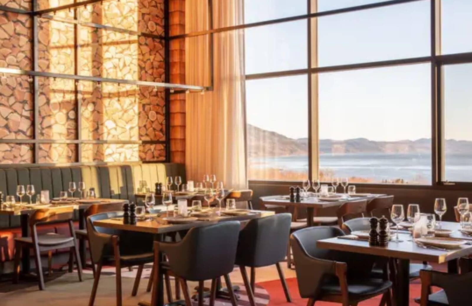 Dining area with booth seating and floor-to-ceiling lake views