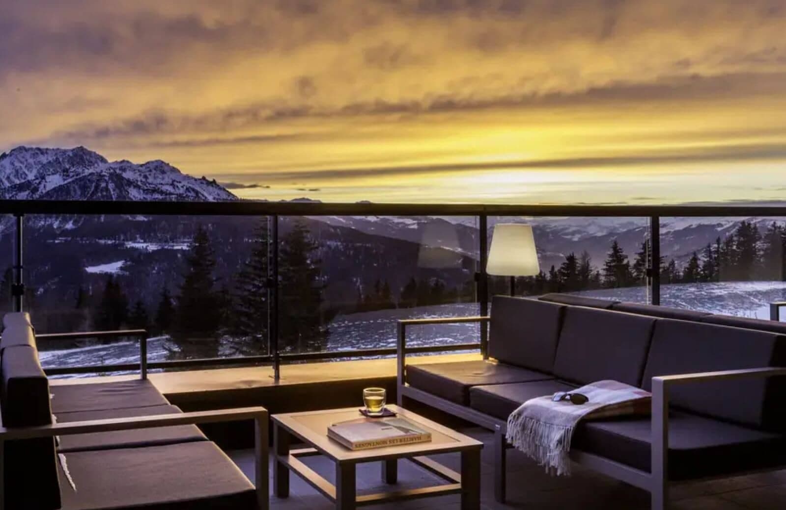 Private balcony with lounge seating and panoramic Alpine sunset views
